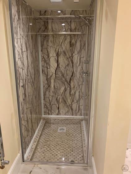Modern bathroom with a marble-effect shower enc...