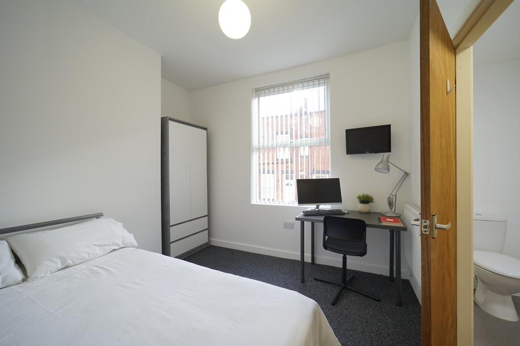 A clean and bright single bedroom featuring a c...