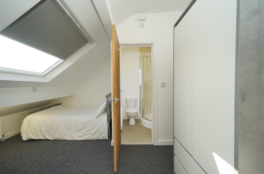 A cozy, well-maintained bedroom with a comforta...