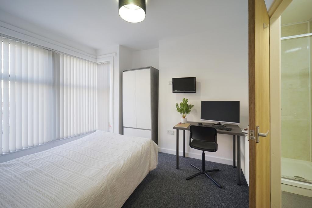A tidy and well-lit bedroom featuring a double ...