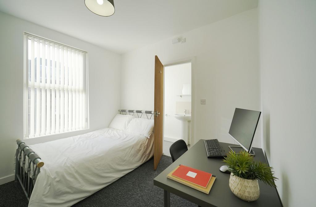 A bright and tidy single bedroom featuring a co...