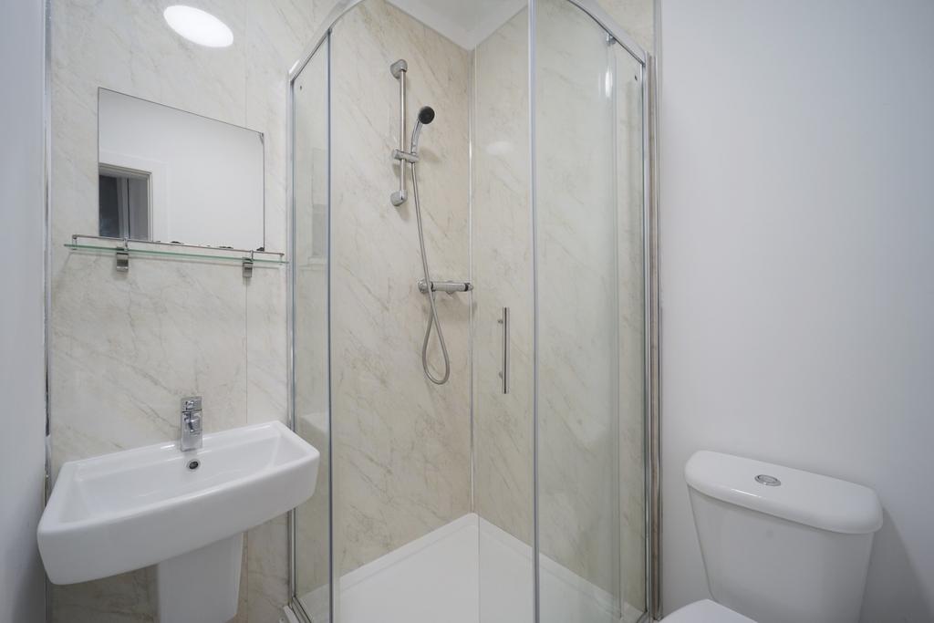 A modern, clean bathroom with a shower enclosur...