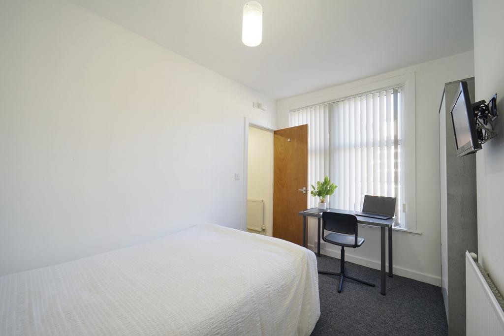 A bright and tidy single bedroom featuring a co...