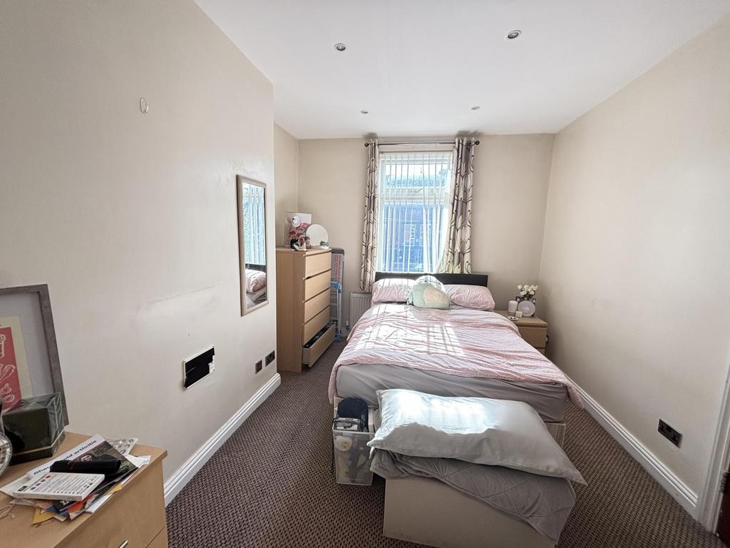 A cozy bedroom featuring a single bed with a pi...