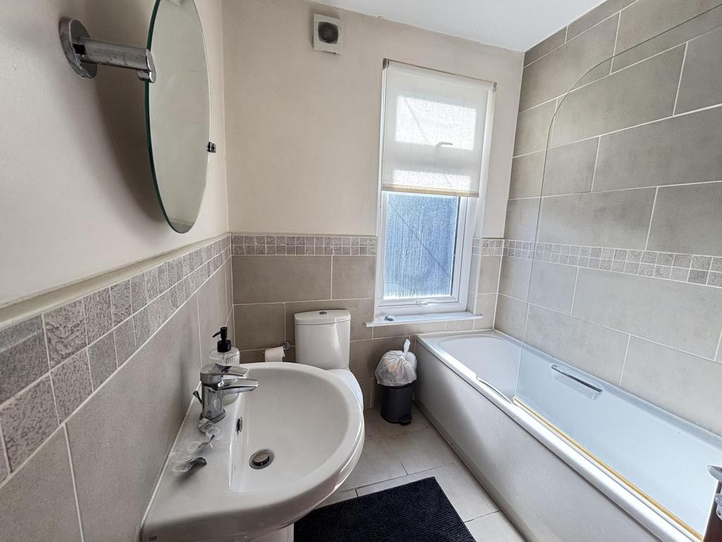 A well-maintained bathroom with a bathtub, sink...