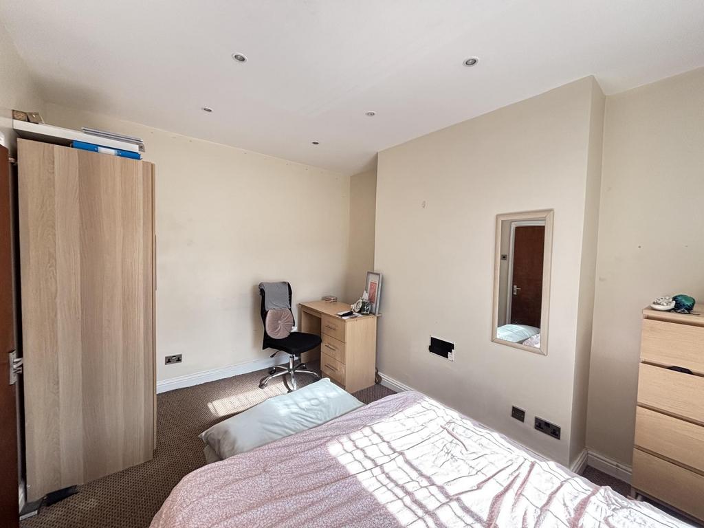 A bright and tidy bedroom featuring a double be...
