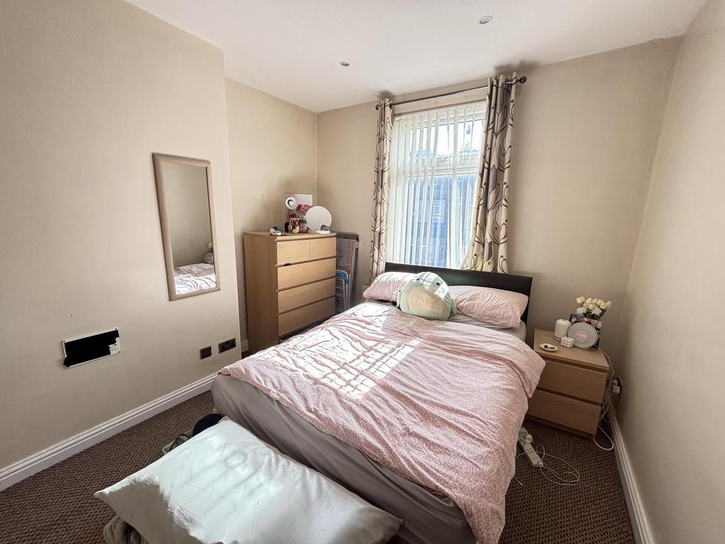 A cozy and well-lit bedroom featuring a comfort...
