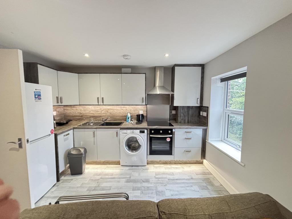 A modern, well-lit kitchen featuring white cabi...