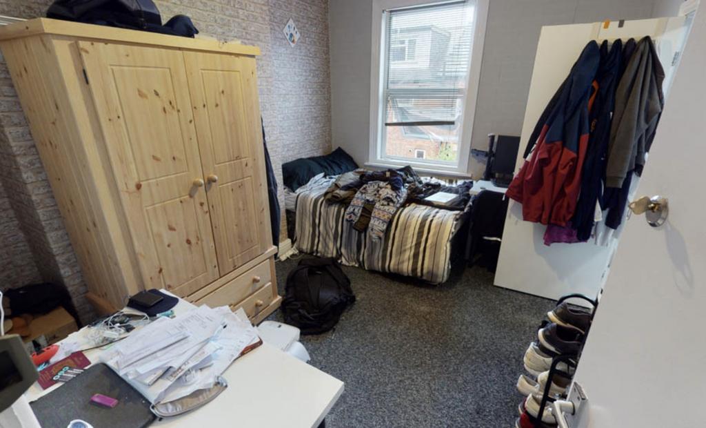 A cozy bedroom featuring a bed, wardrobe, and s...