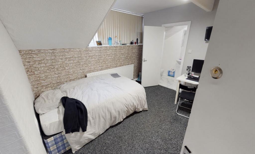 A clean and cozy student bedroom with a comfort...