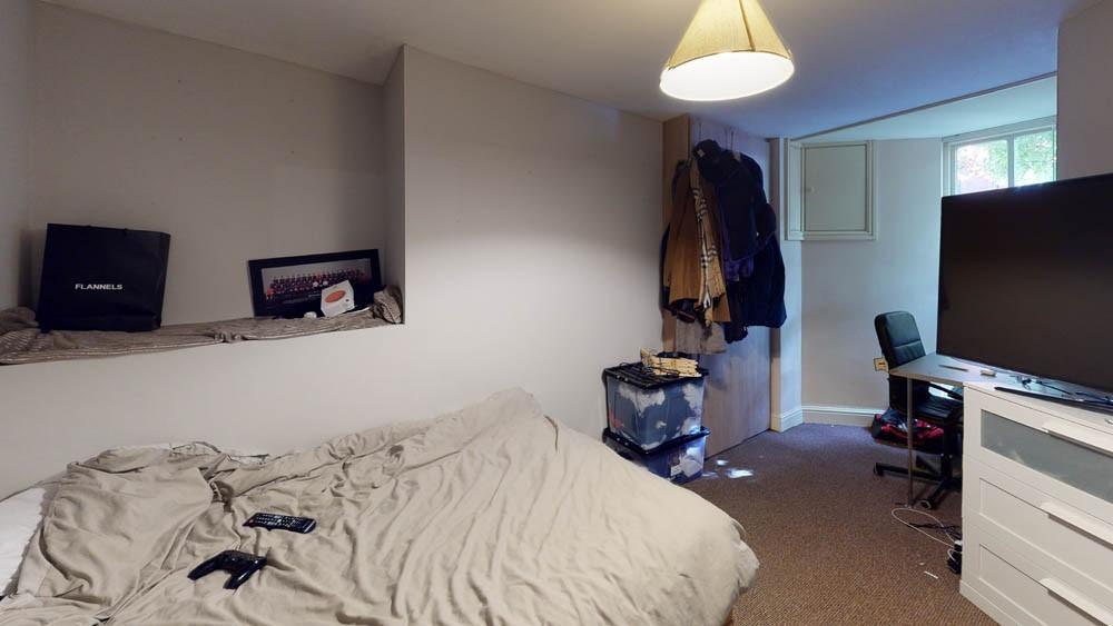 A cozy bedroom with a neatly made bed, a window...