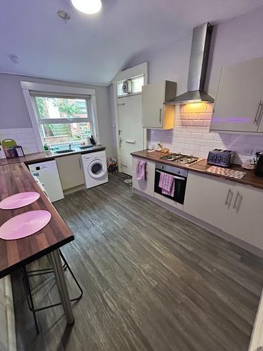 Bright and modern kitchen featuring large windo...