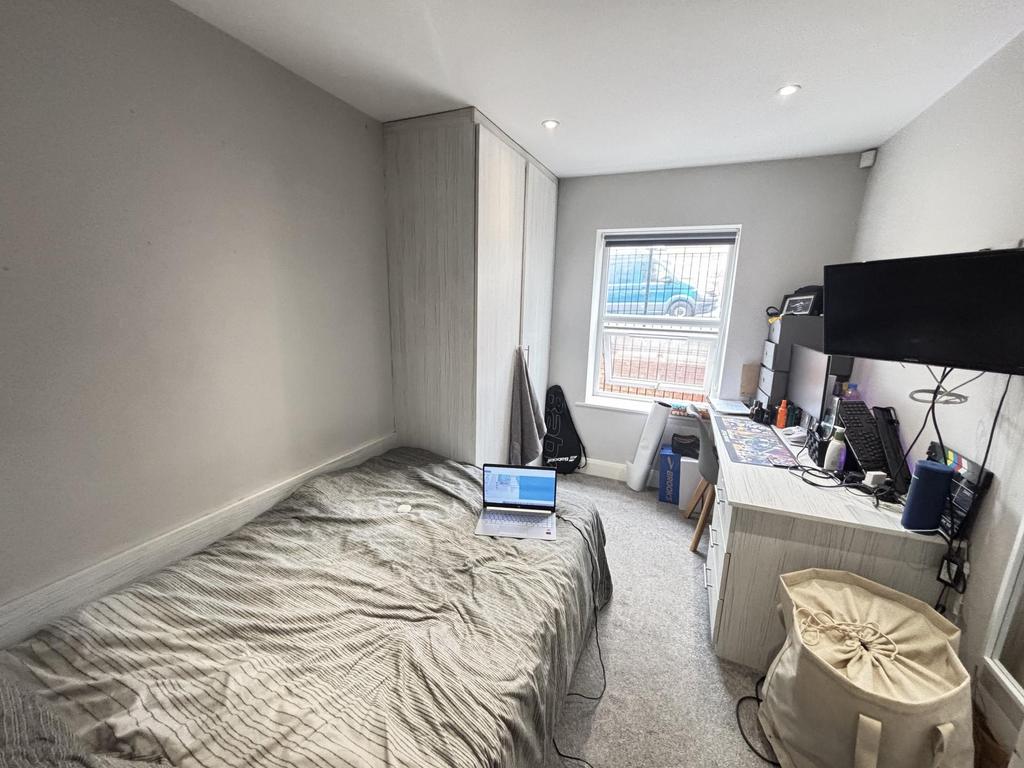 A cozy bedroom featuring a neatly made bed posi...