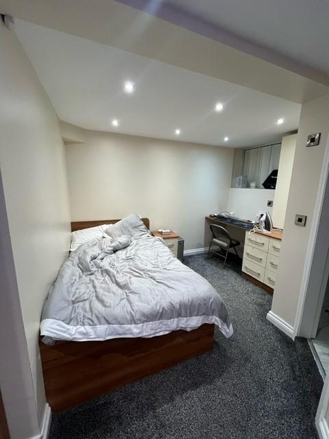 A spacious and well-lit master bedroom featurin...