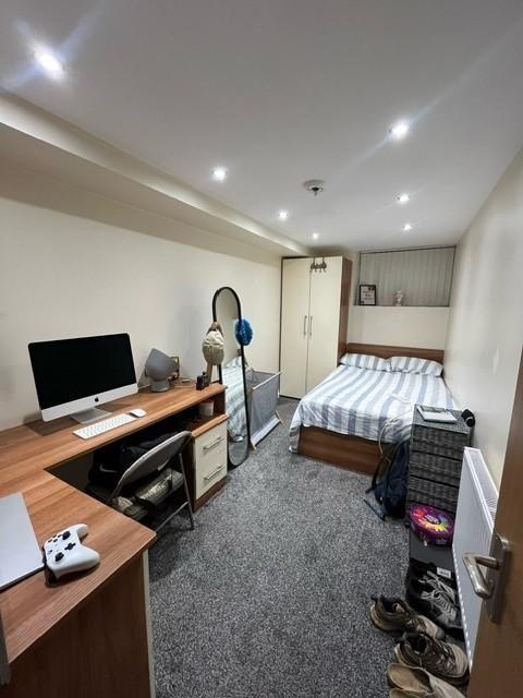 A cozy student bedroom featuring a double bed, ...