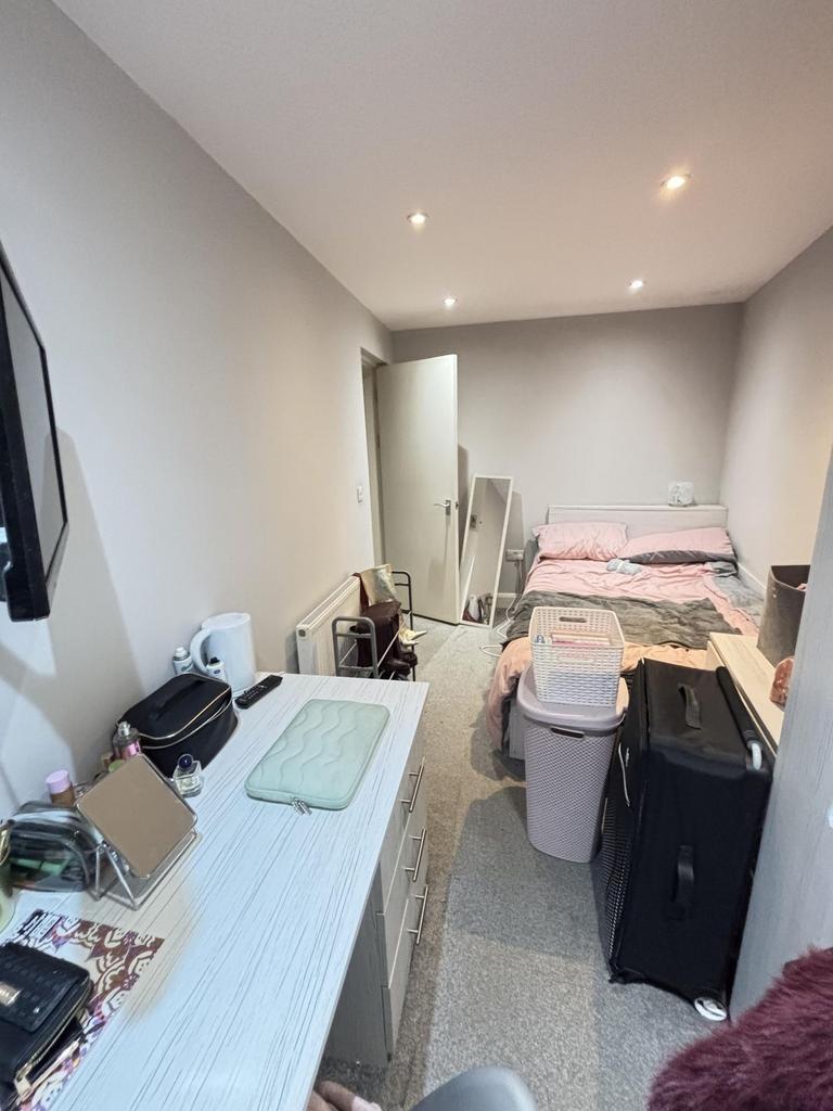 A spacious master bedroom featuring a comfortab...