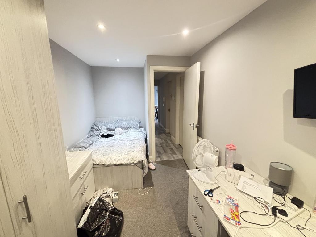 A bright bedroom with a double bed positioned a...