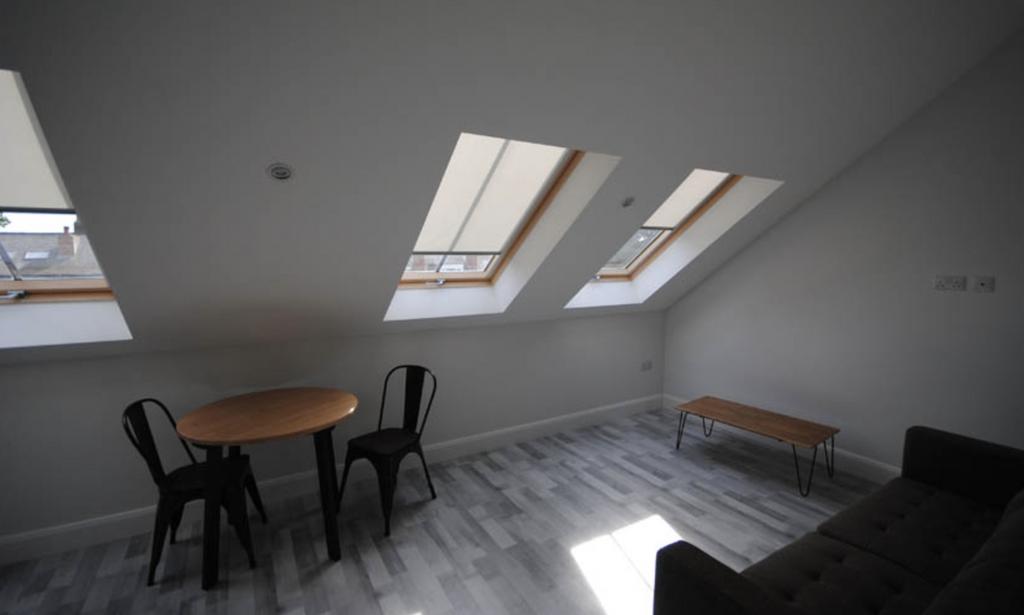 A bright, modern living room with large skyligh...