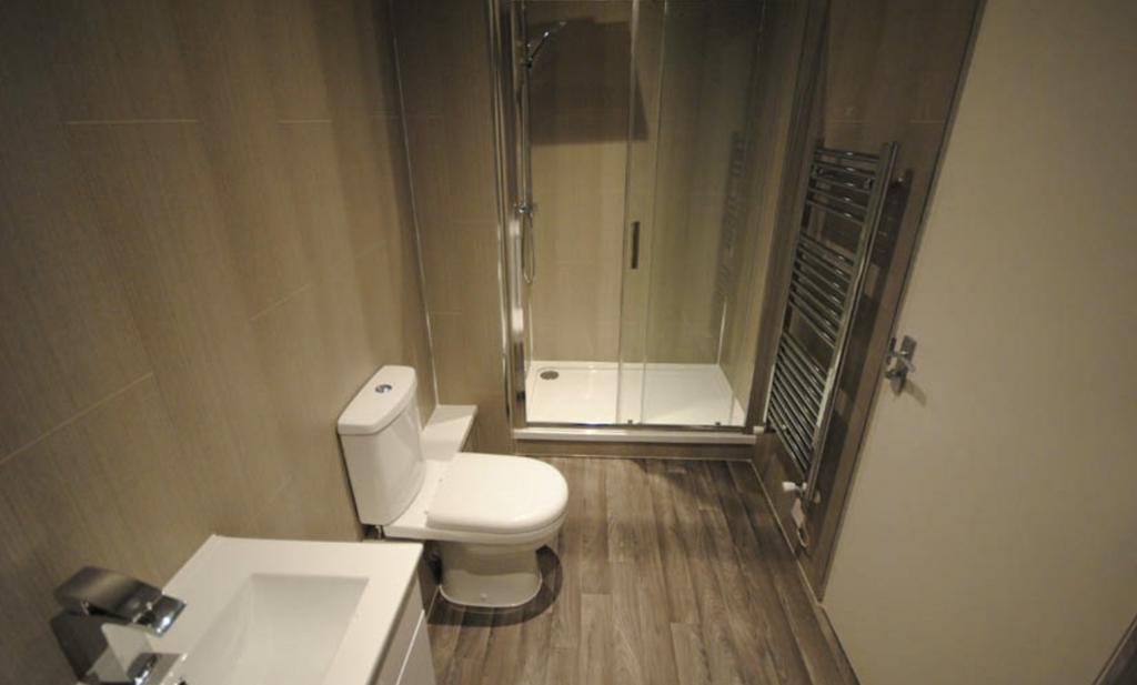 A modern, clean bathroom featuring a toilet, wi...