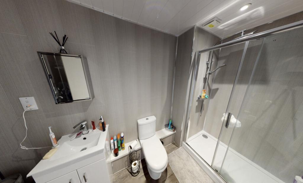A clean and modern bathroom with a spacious sho...