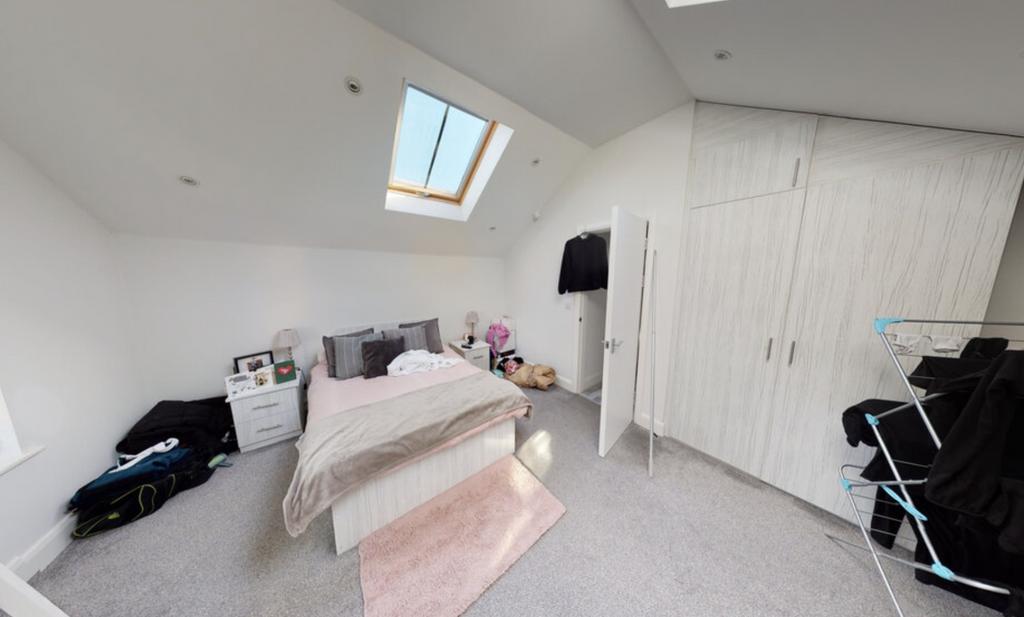 A bright and airy bedroom with a cozy bed, ampl...