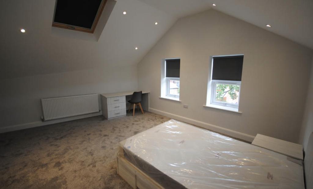 Bright and spacious bedroom with large windows ...