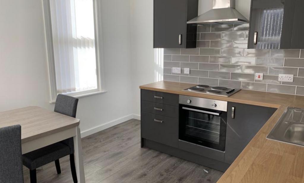 A modern kitchen area with sleek dark cabinetry...
