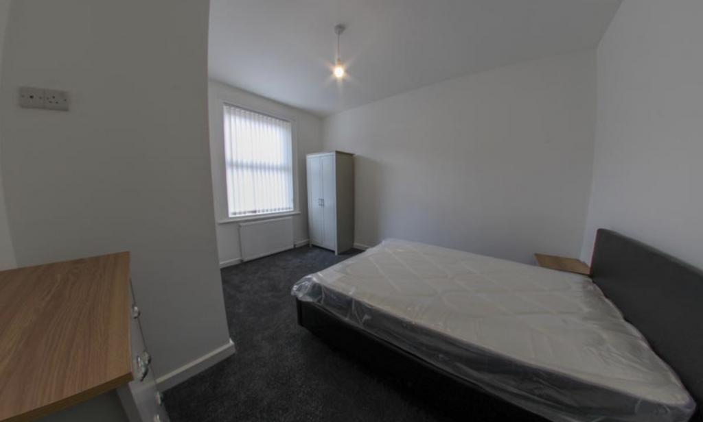A clean and well-lit single bedroom featuring a...