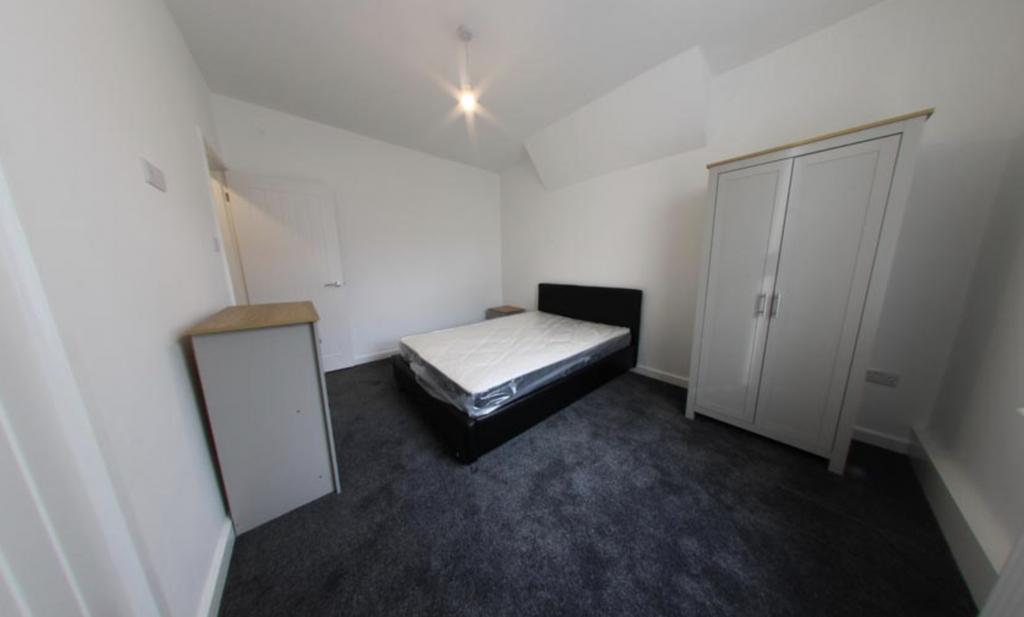 A small, tidy room with a simple, clean bathroo...
