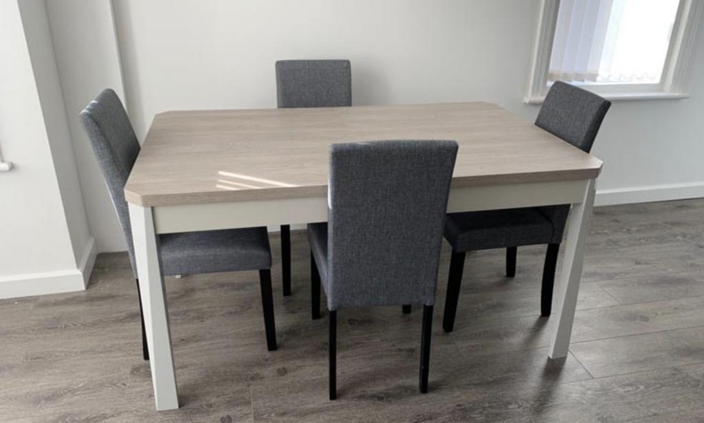 Bright, modern dining area with a light wood ta...