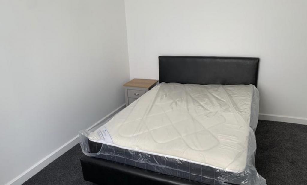 A spacious master bedroom featuring a double be...