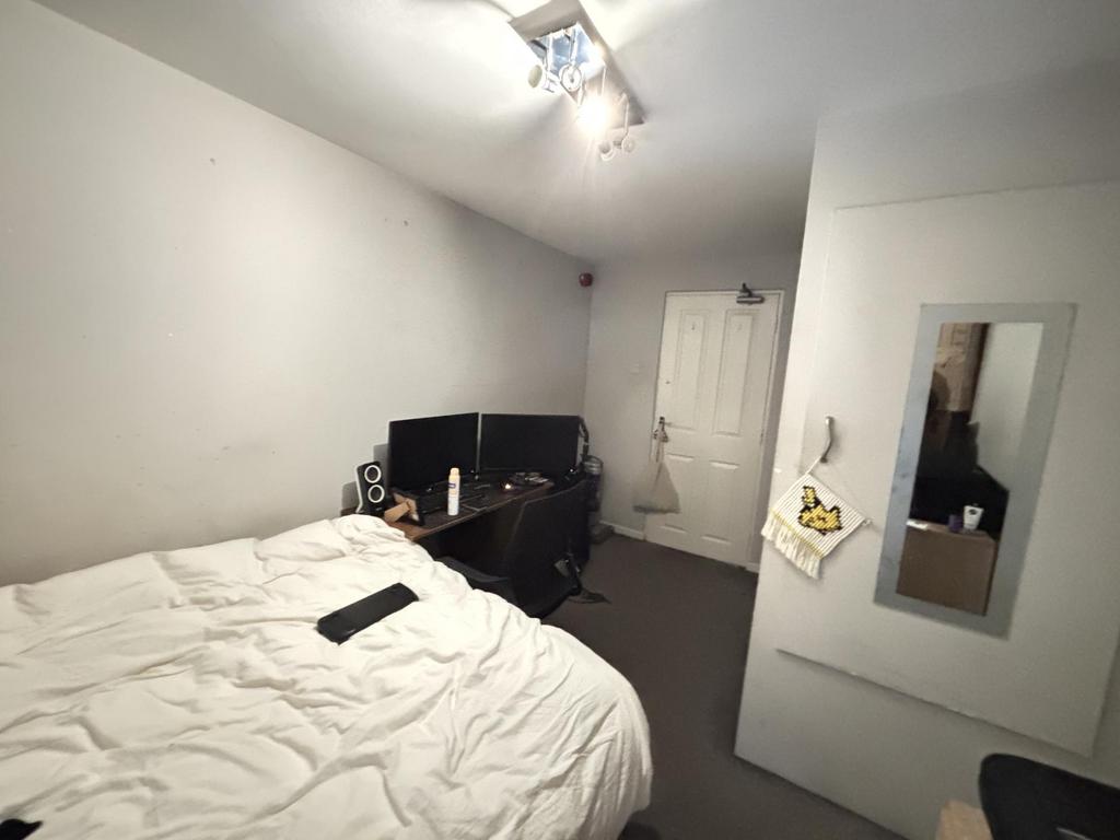 A spacious master bedroom featuring a comfortab...