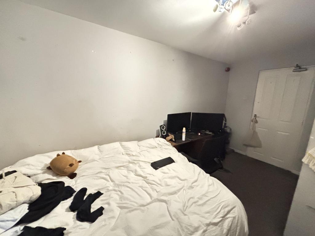 A cozy bedroom featuring a bed with white beddi...