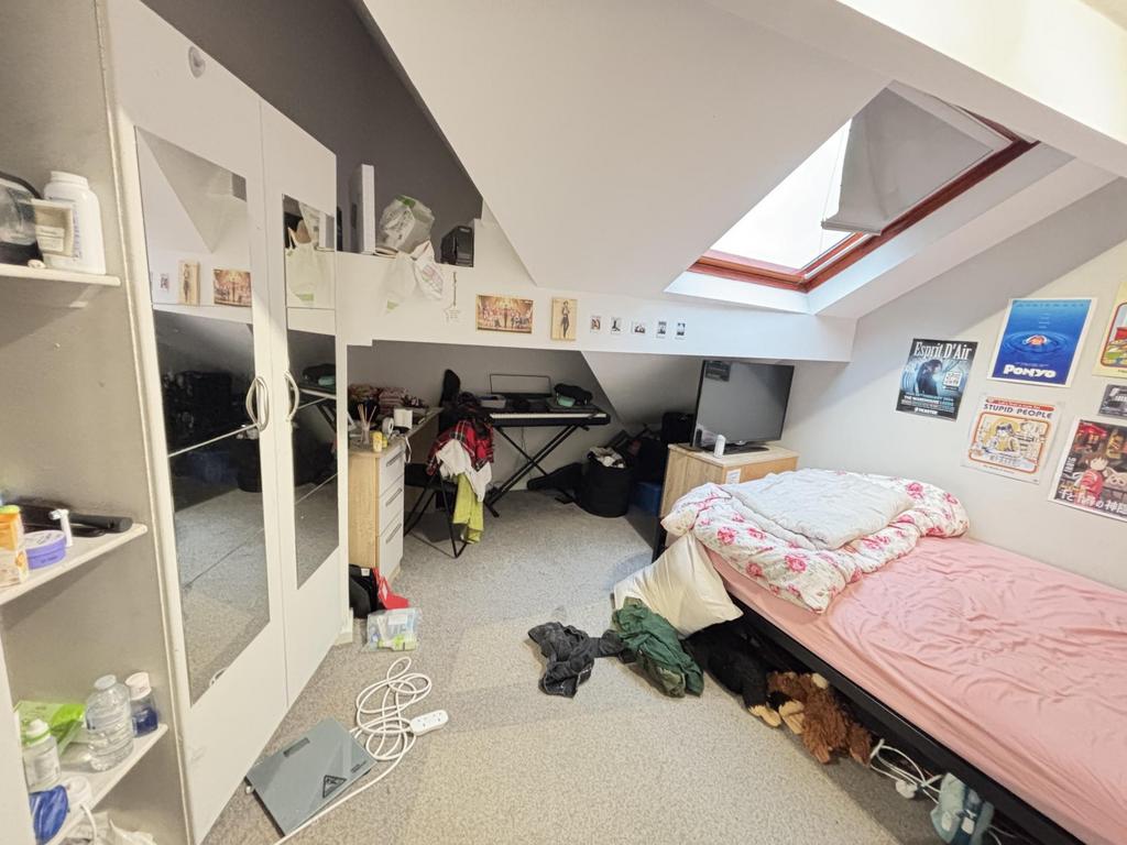 A cozy bedroom under a sloped ceiling featuring...