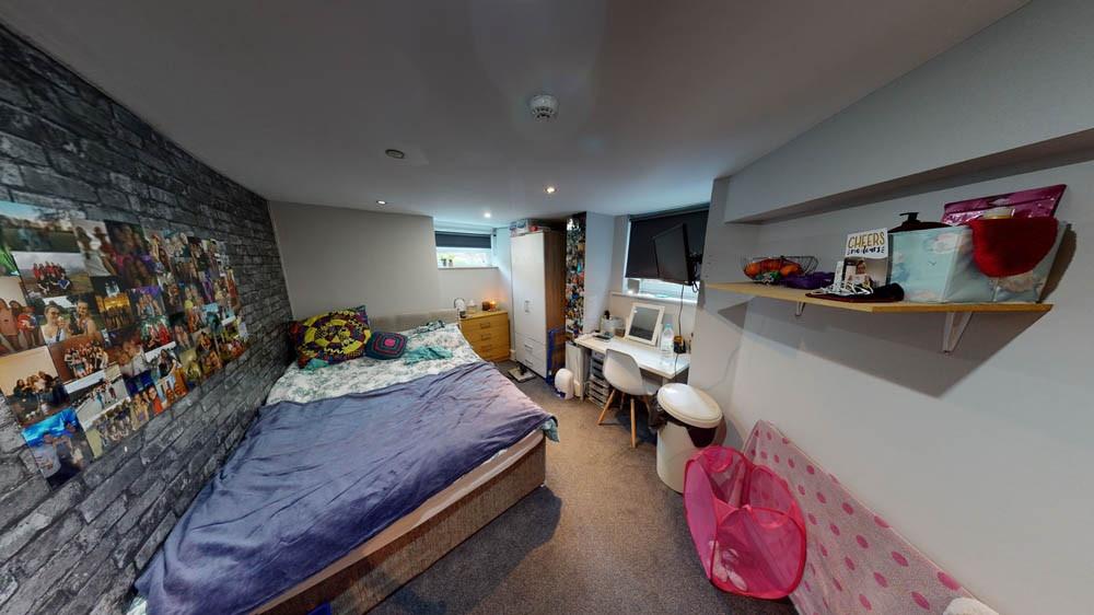 A cozy and well-lit bedroom featuring a spaciou...