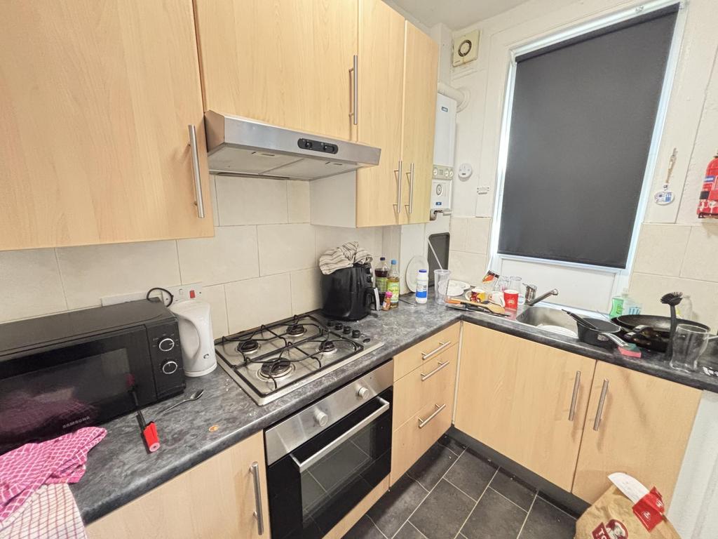 A compact kitchen area with modern fitted units...