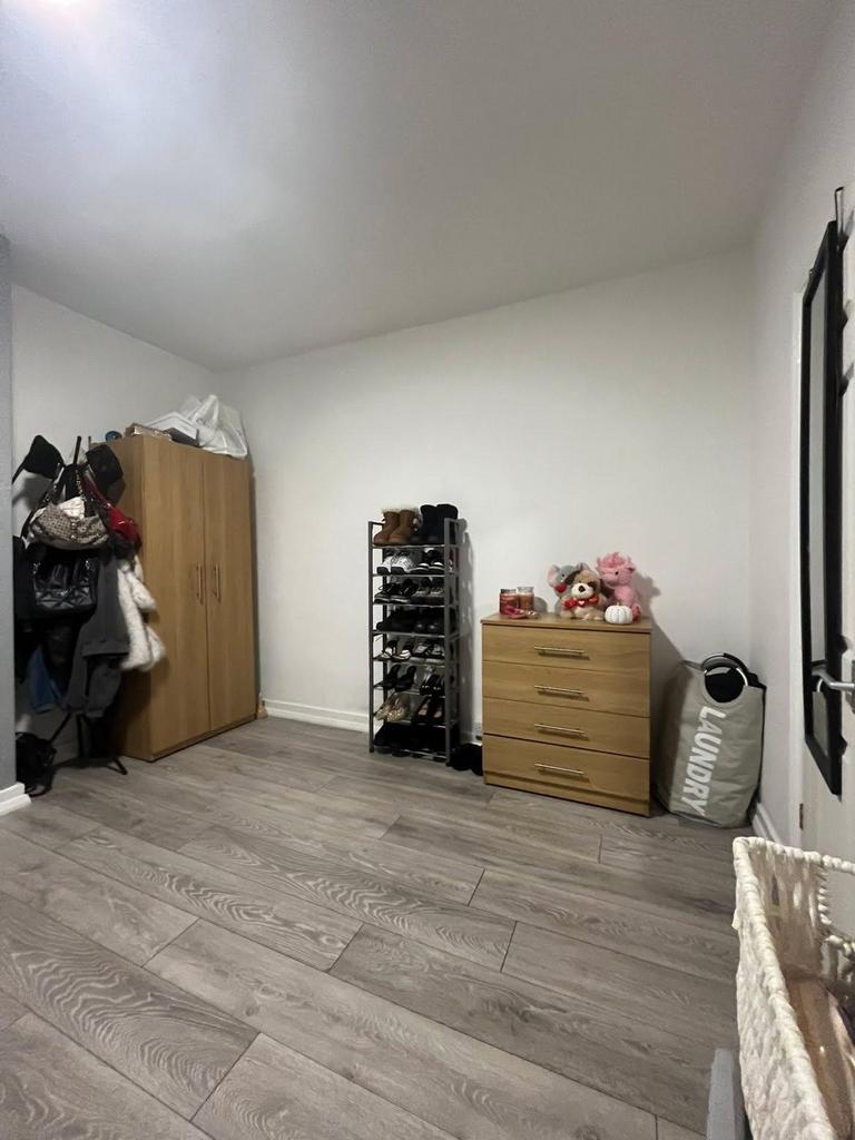 A cozy bedroom featuring a wardrobe, a small ch...