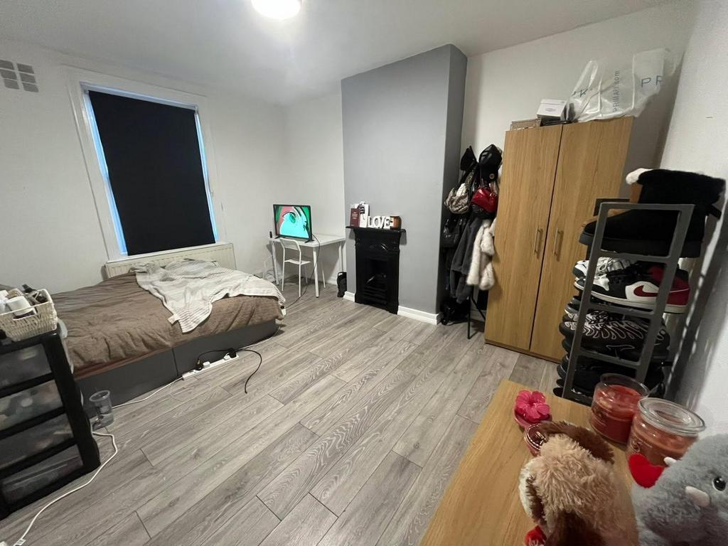 A modest bedroom with a single bed, desk, and w...