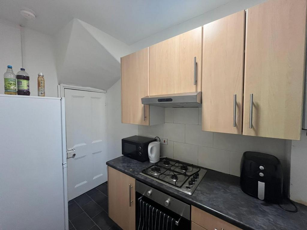 A modern, clean kitchen with wooden cabinets, a...