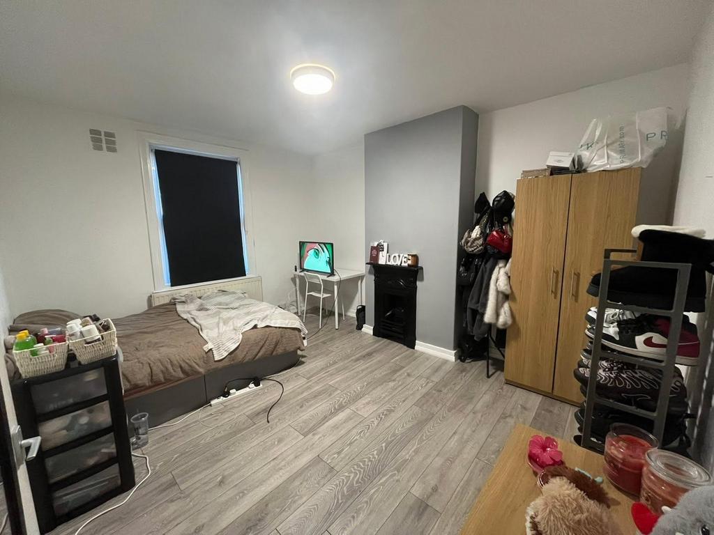 A well-lit bedroom featuring a double bed, a wa...