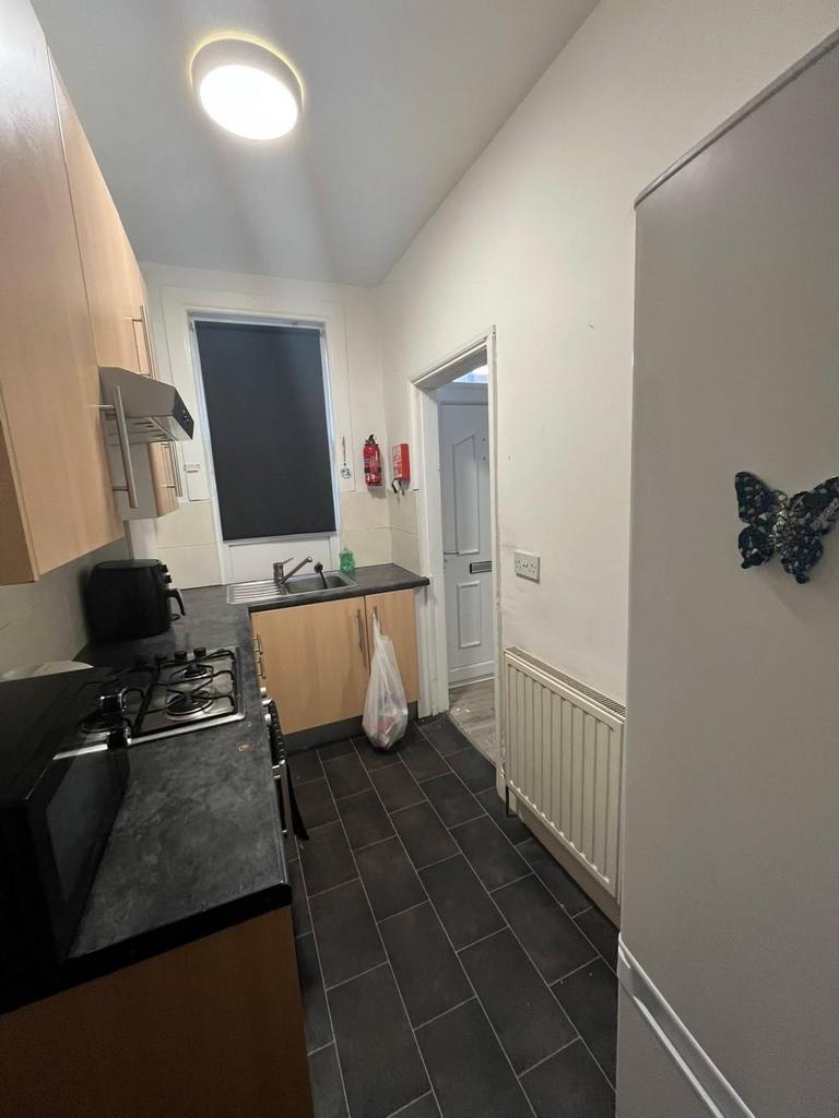 A modern and tidy kitchen area with wooden cabi...
