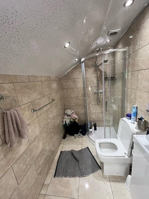 A modern, clean bathroom featuring a glass show...