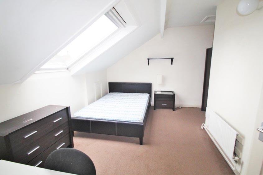 A bright and tidy bedroom featuring a comfortab...
