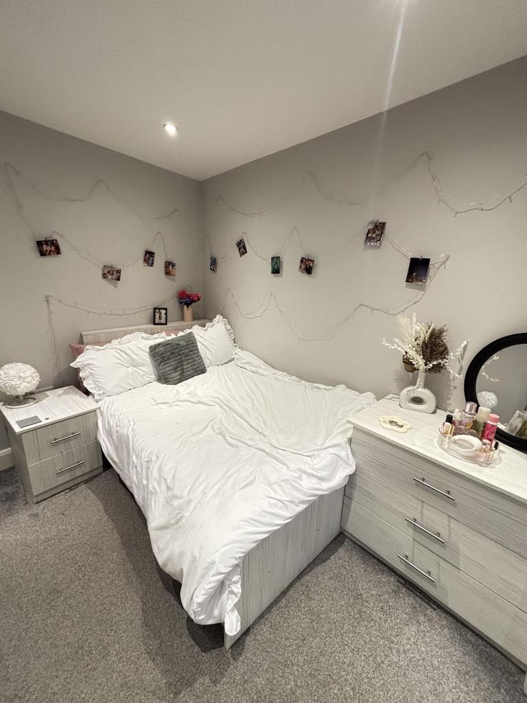 A spacious master bedroom featuring a comfortab...