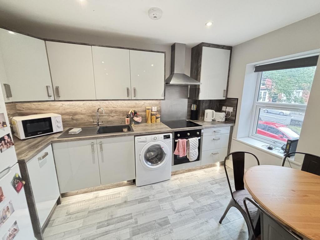 Bright and modern kitchen with ample cabinet st...