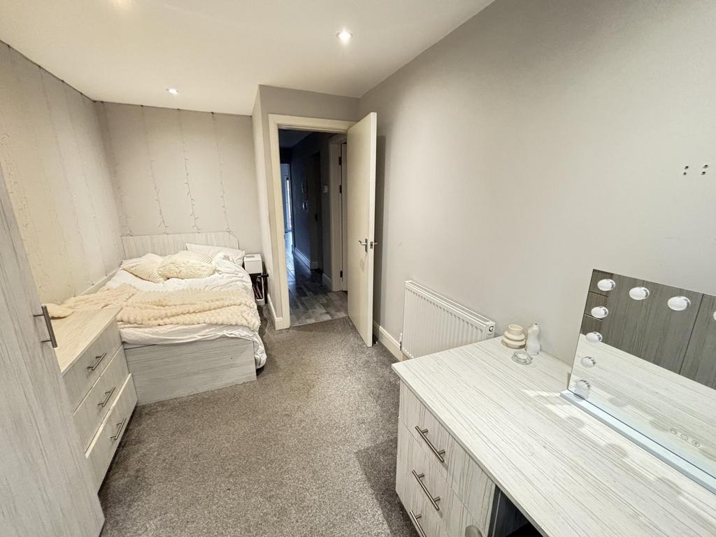 A modest bedroom with a single bed, a bedside t...