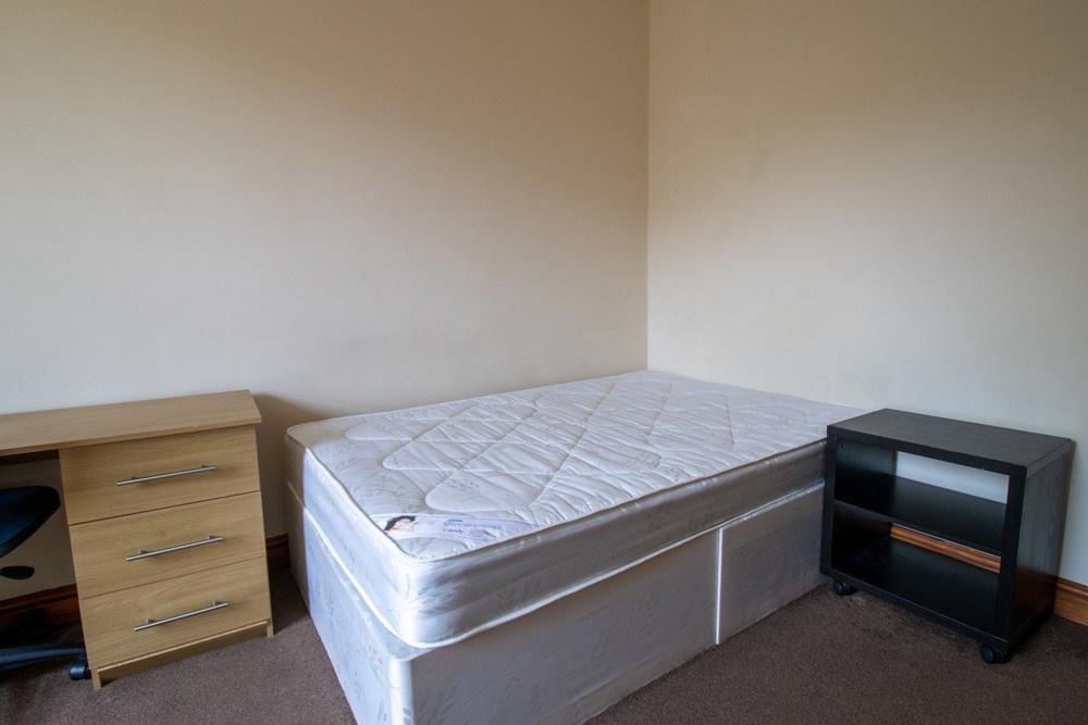 A modest single bedroom featuring a single bed ...