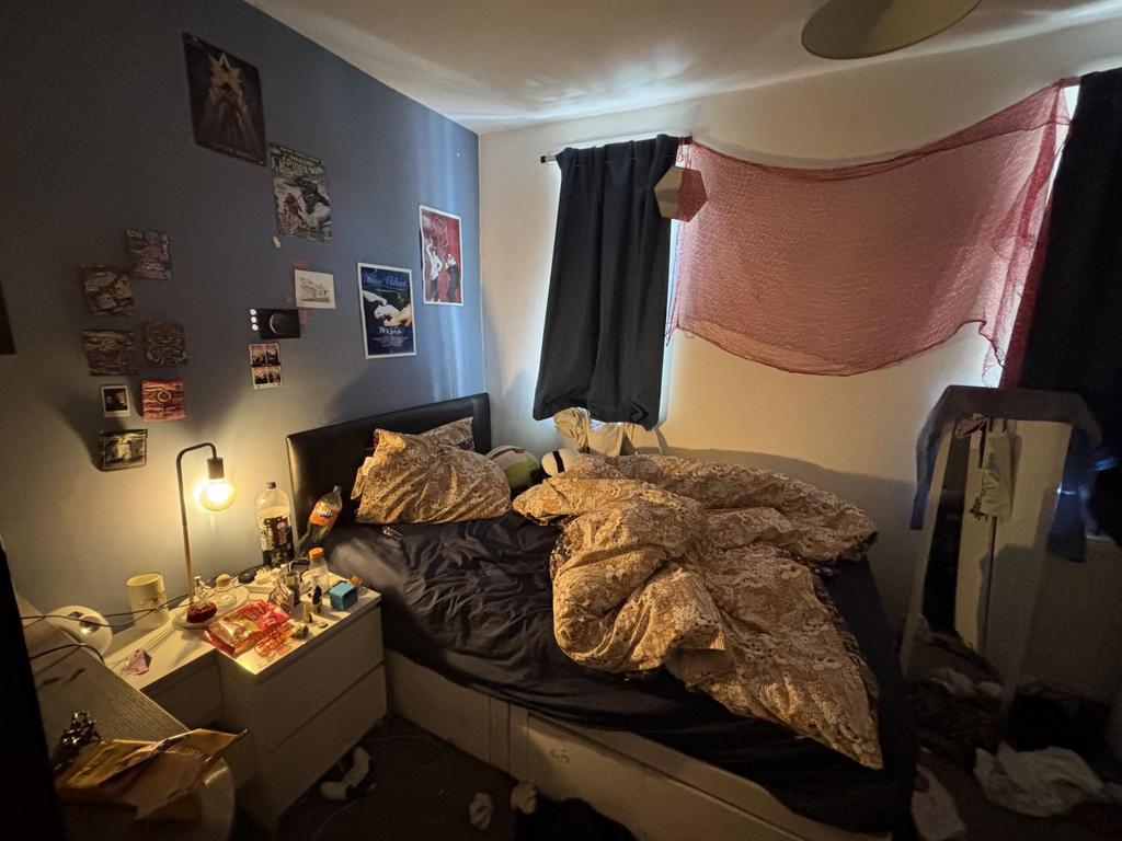 A cozy bedroom with a bed, nightstand, and some...