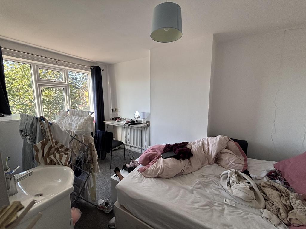 A softly lit bedroom featuring a bed with pink ...