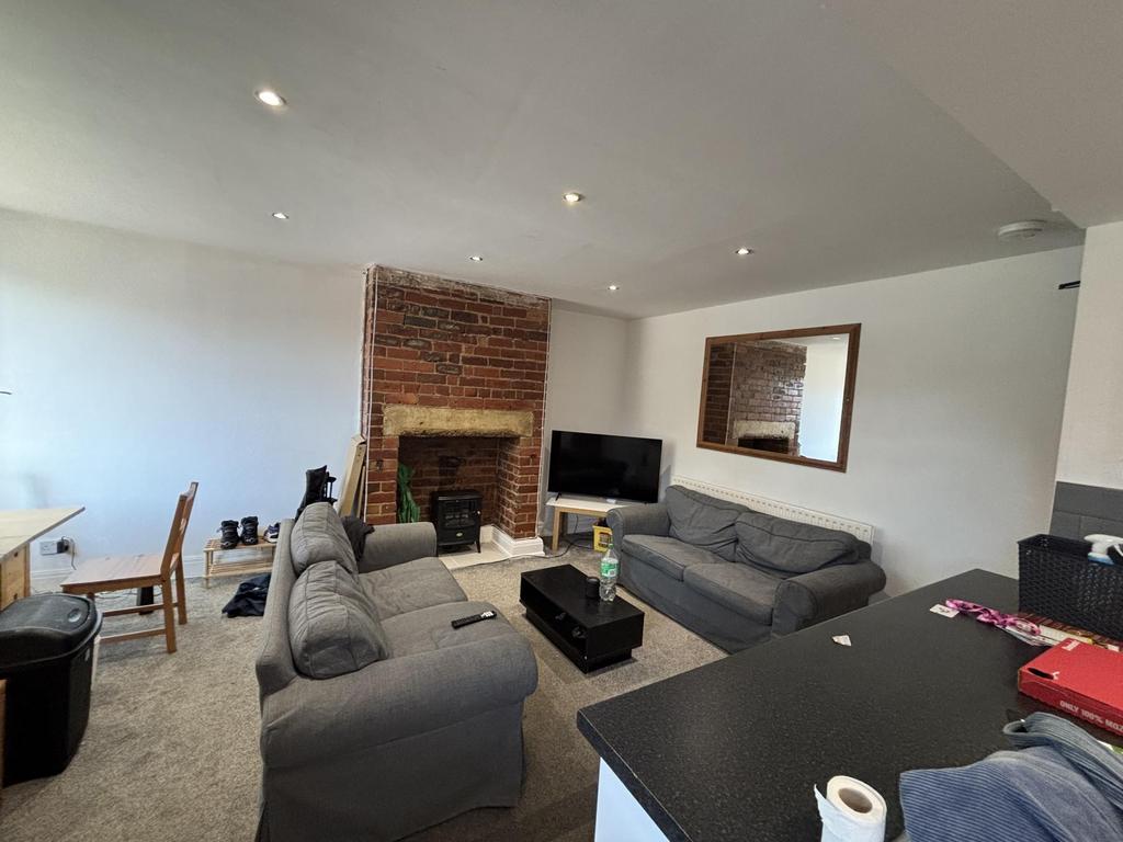 A spacious and well-lit living room featuring c...